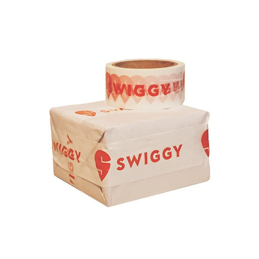 Food delivery tape for Swiggy partners, white printed roll on top of a food parcel sealed with it